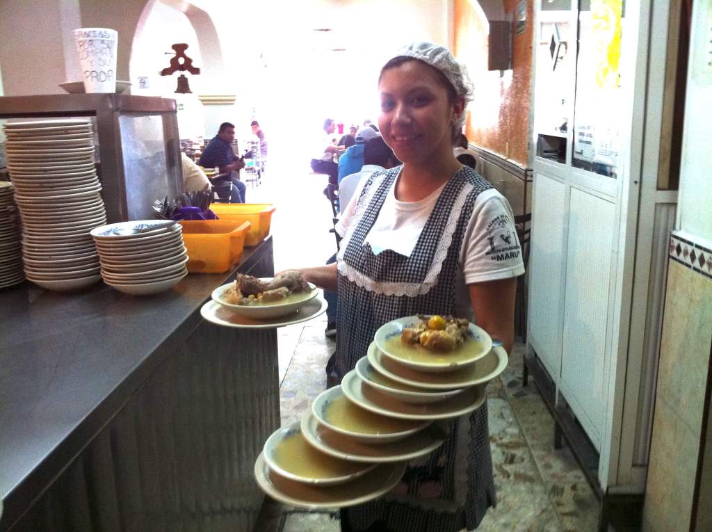 Mesera cargando exceso de platos