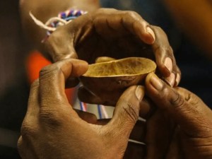 Manos sosteniendo un recipiente pequeño.