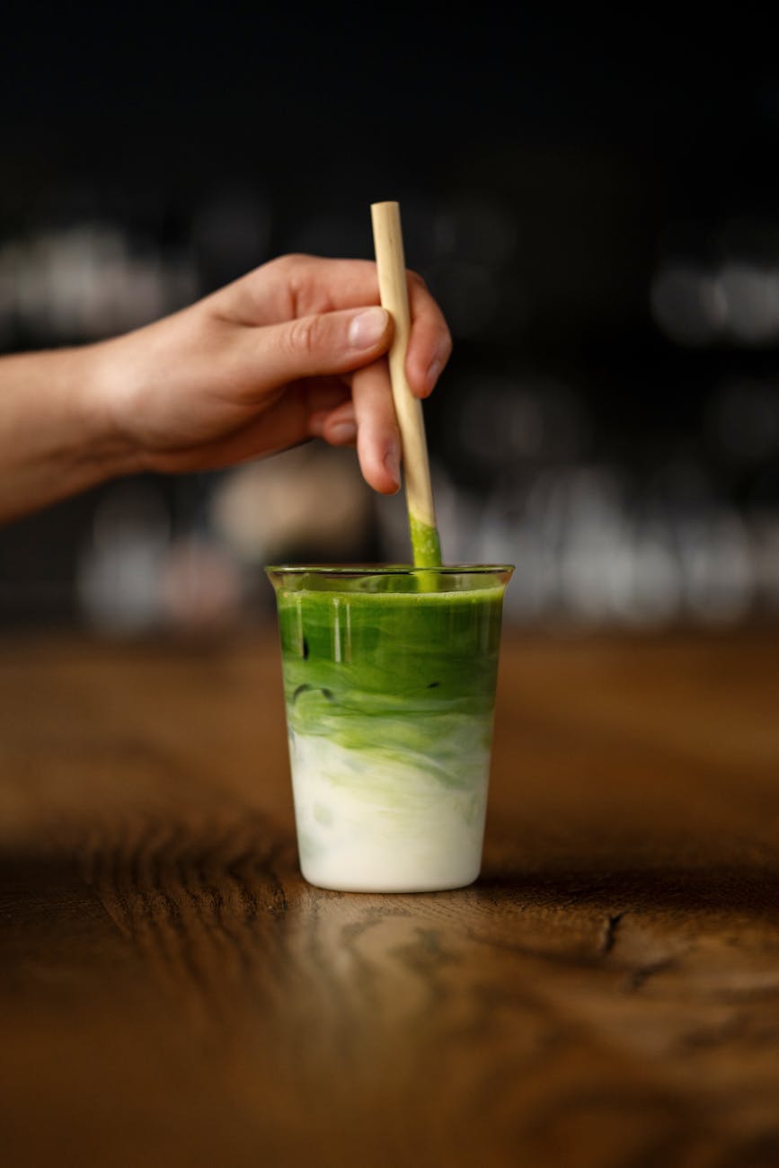 hand holding straw in cocktail glass