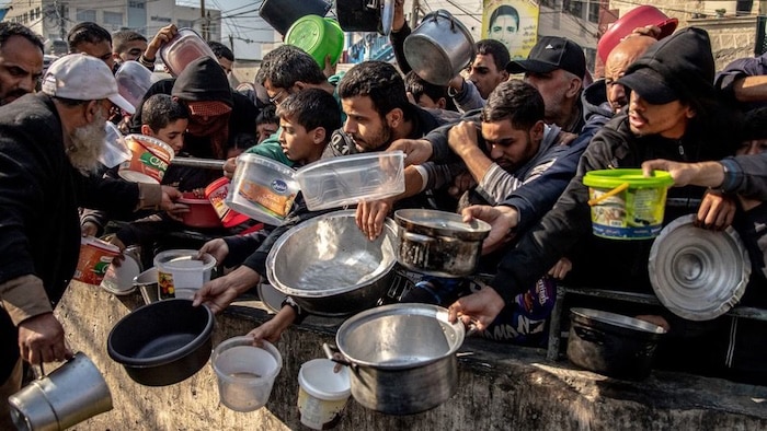Desplazados por el conflicto esperan comida en el campamento de Al-Shaboura, en Rafah, al sur de Gaza.